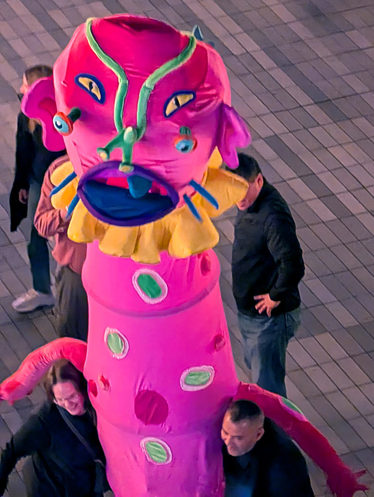 Luna Luna larger than life size pink creature puppet character sculpture, colorful inflatable art figure, surreal carnival art installation, contemporary pop art character, immersive art exhibition.