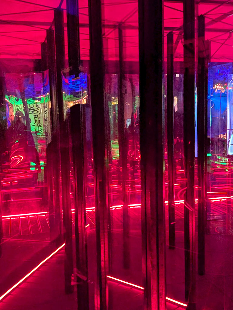 The inside of the Lichtenstein Luna Luna maze with glass walls and red lighting