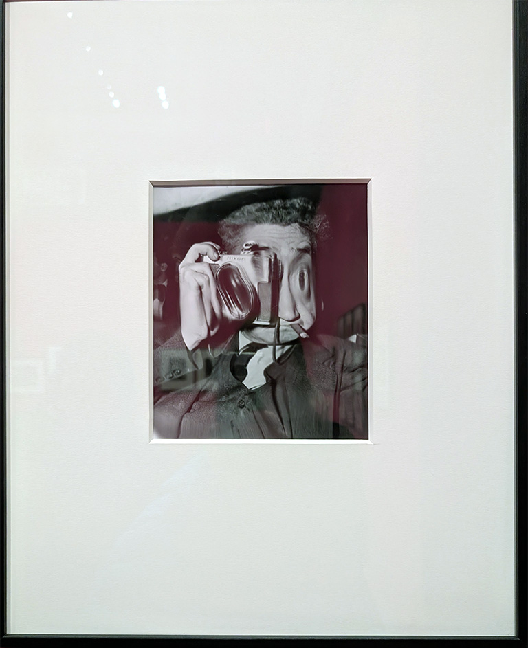 Surreal black and white self-portrait of photographer Weegee featuring a distorted reflection holding a vintage camera, iconic fine art image with abstract visual effects.