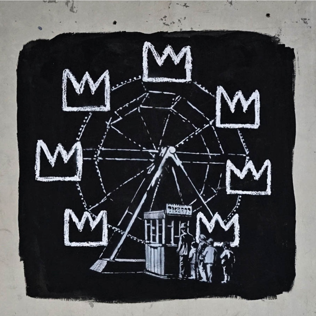 A black-and-white Banksy mural depicts a Ferris wheel outlined in chalk-like lines, each car replaced with crown symbols referencing Jean-Michel Basquiat, as a small group of people stands at the base, an apparent nod to Basquiat’s Luna Luna Ferris wheel.